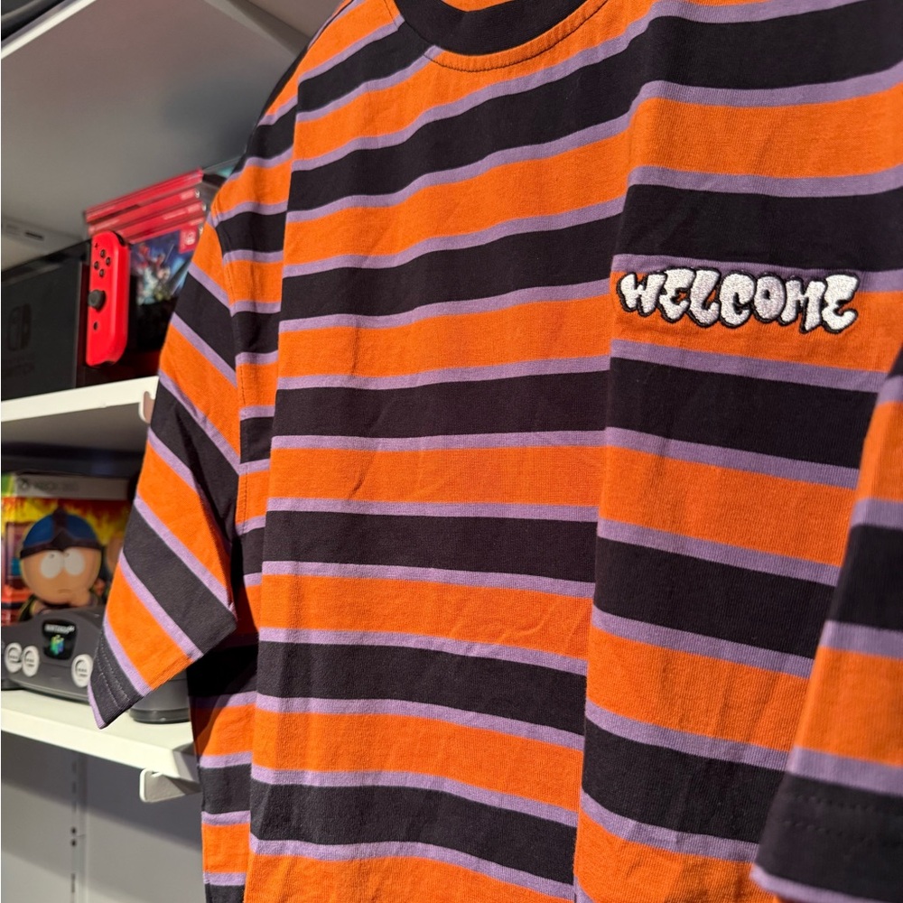 Vibrant Striped T-Shirt with Welcome Logo